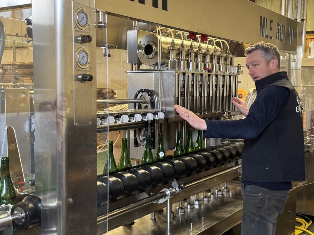 Un producteur de cidre présente sa chaîne d'embouteillage.