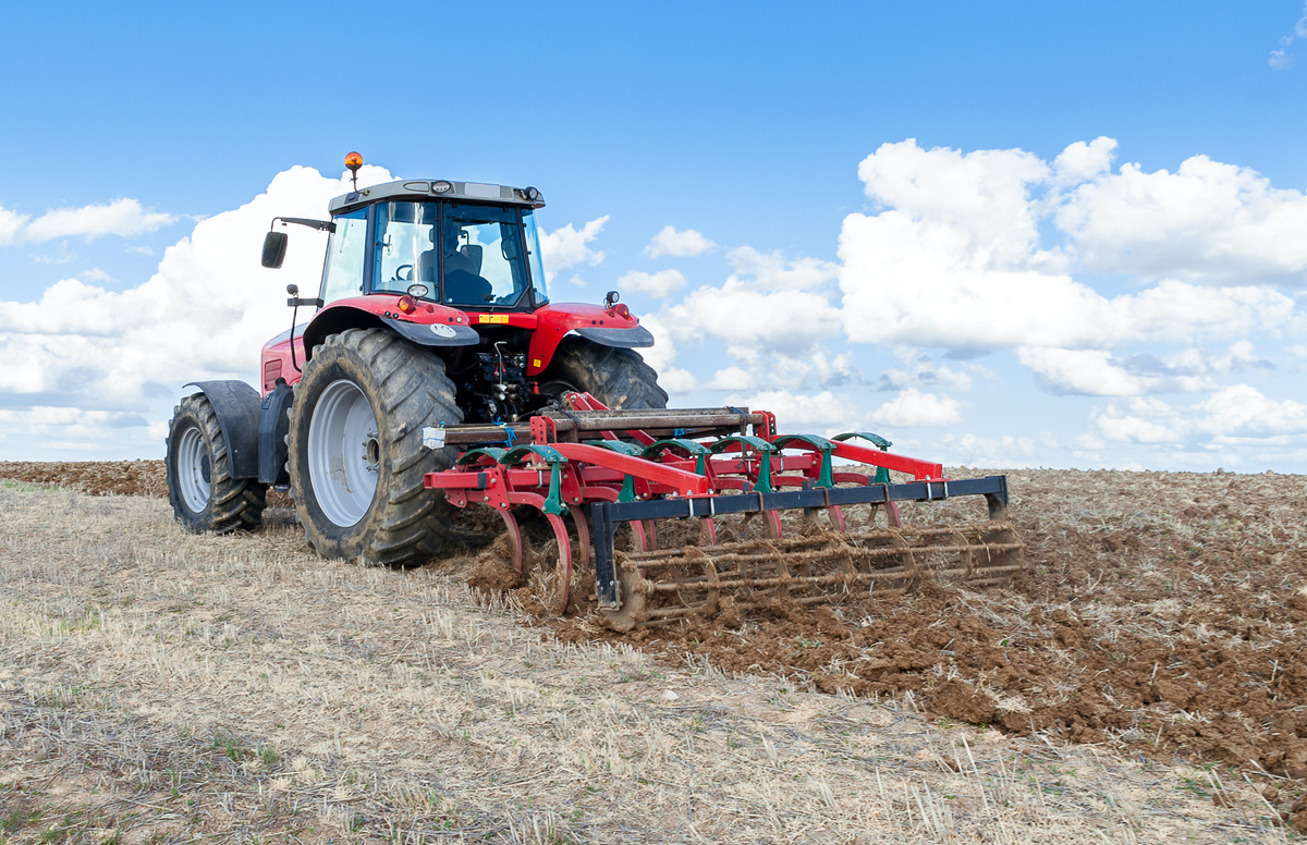 tracteur dans un champ travaillant le sol - Illustration Comment bien déléguer son activité agricole