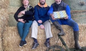 Les éleveurs de la bergerie de la Corbière sur une botte de paille