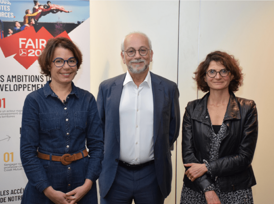 2 femmes et 1 hommes devant l'affiche 