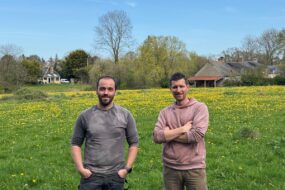 Deux hommes devant une prairie contenant des fleurs jaunes